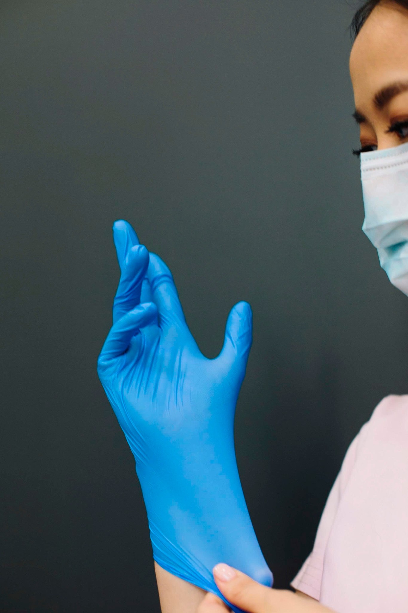Medical professional wearing blue nitrile gloves